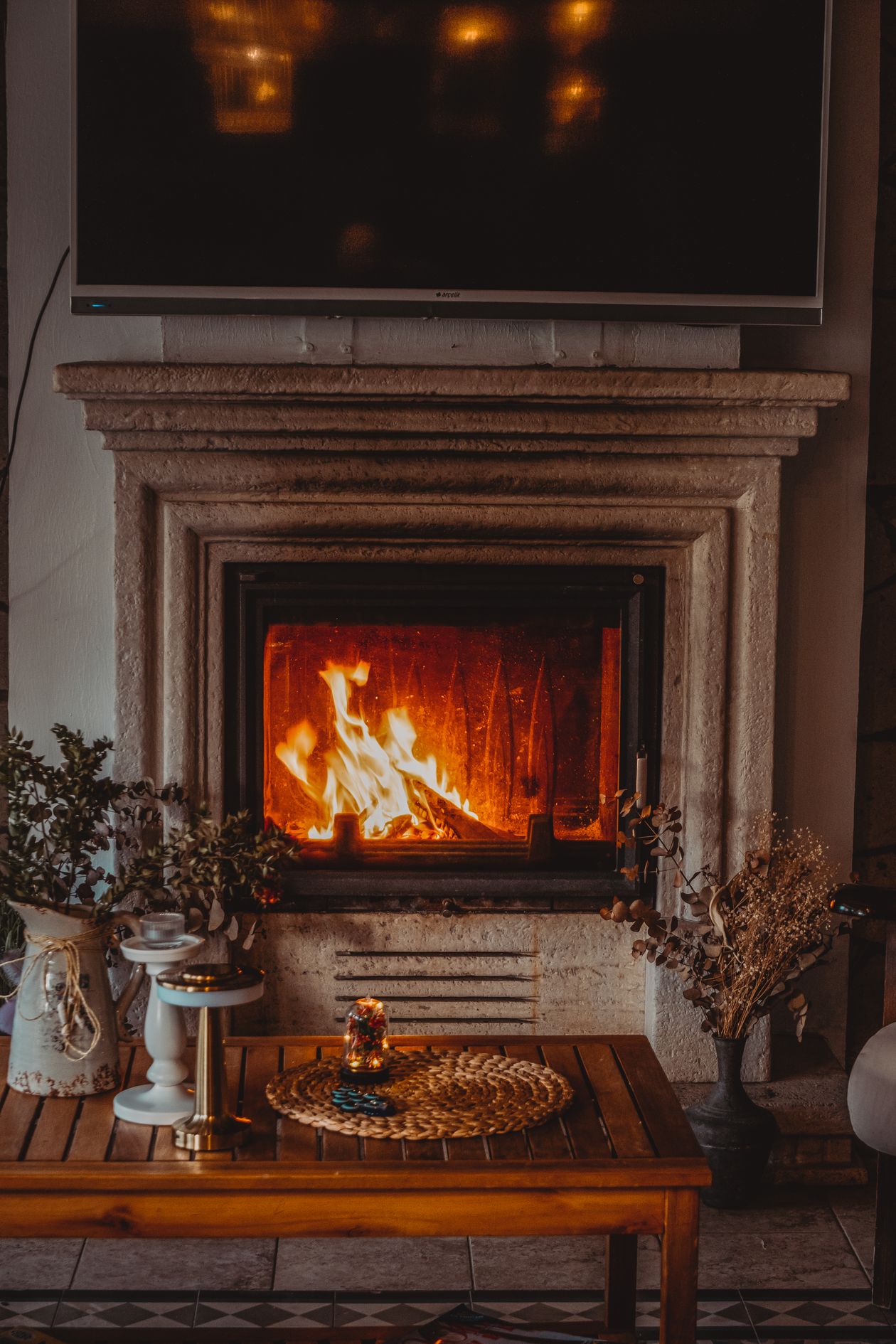 Stone fireplace with a lit fire warming a Christchurch living room