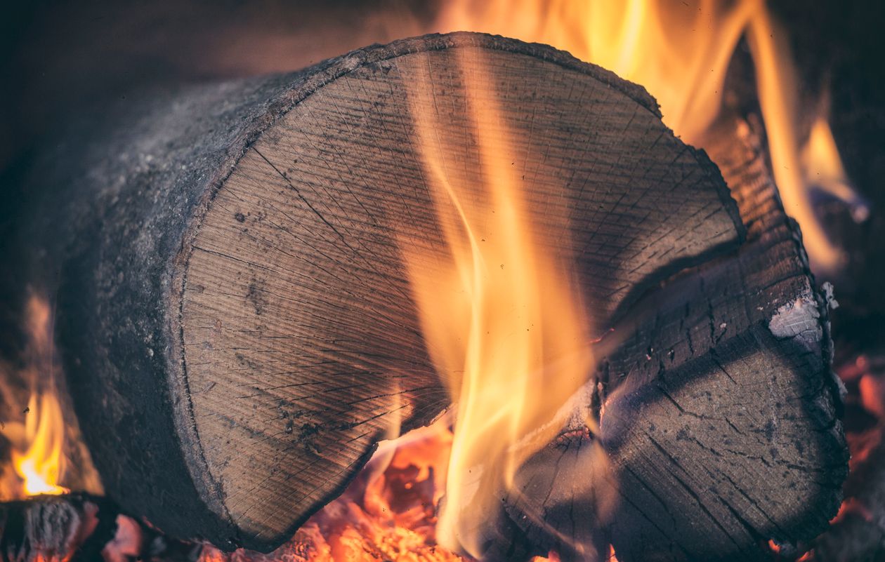 Macro view of a burning log with flames — seasoned firewood burns cleaner